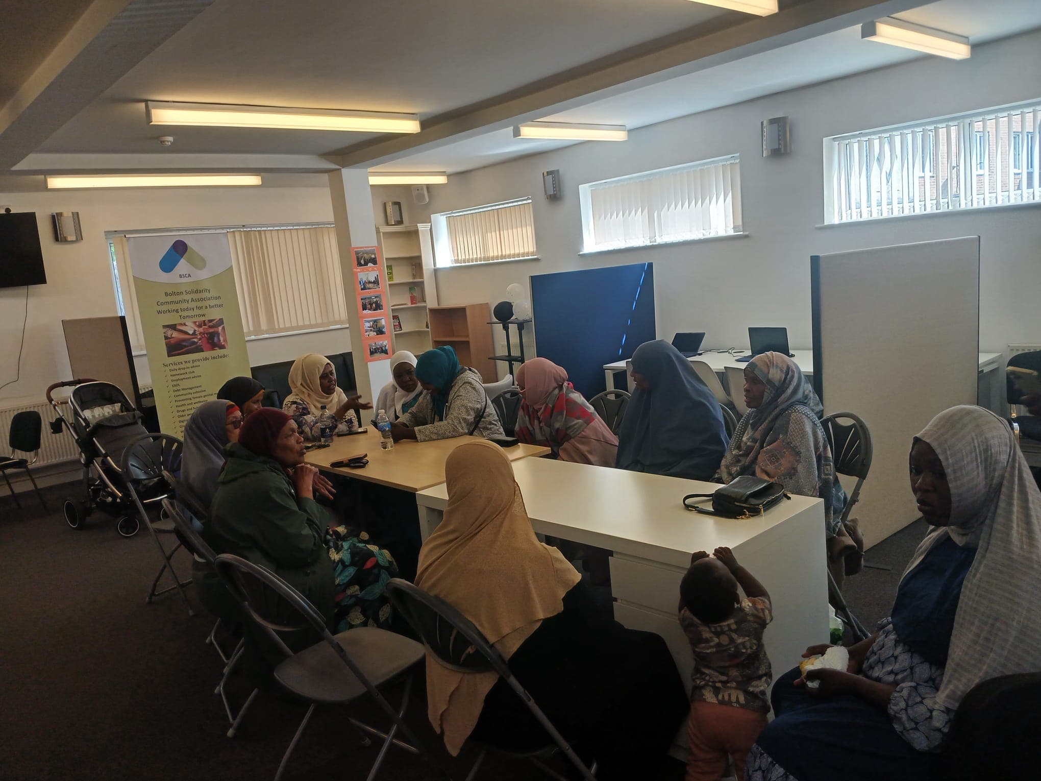 A women's group meeting around tables at the BSCA community centre
